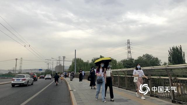 阵雨遇上北京早高峰 市民打伞出行
