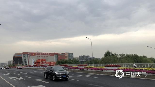 阵雨遇上北京早高峰 市民打伞出行
