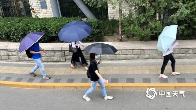 阵雨遇上北京早高峰 市民打伞出行