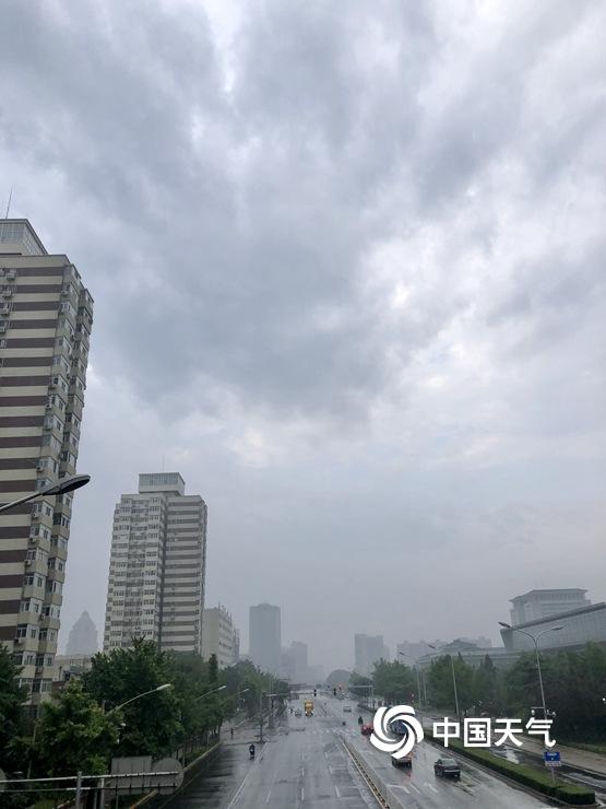 北京雷阵雨上线 天空阴沉路面湿滑
