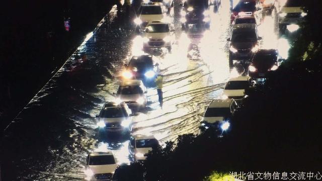 夜晚突降暴雨,武汉交警充当马路“航标”