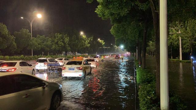 夜晚突降暴雨,武汉交警充当马路“航标”