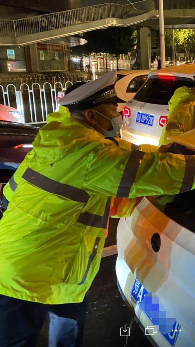 夜晚突降暴雨,武汉交警充当马路“航标”