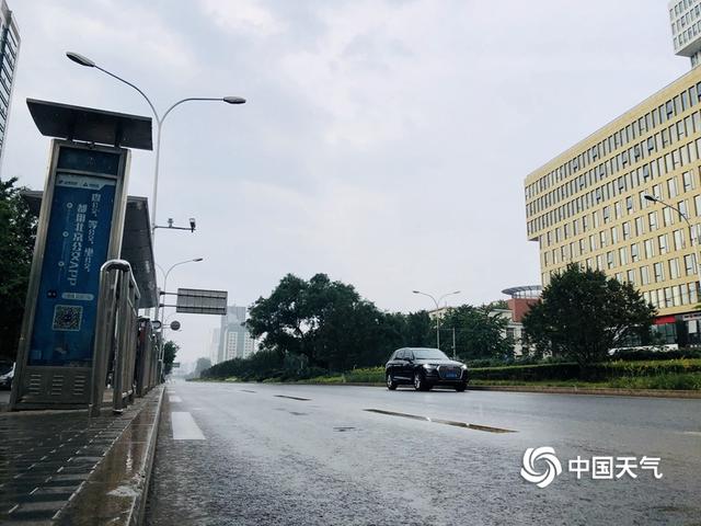 乌云携雨来 北京街头市民撑伞出行