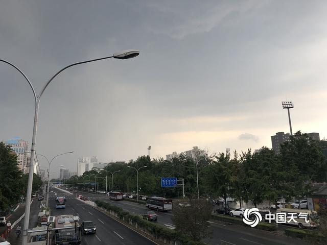 乌云携雨来 北京街头市民撑伞出行