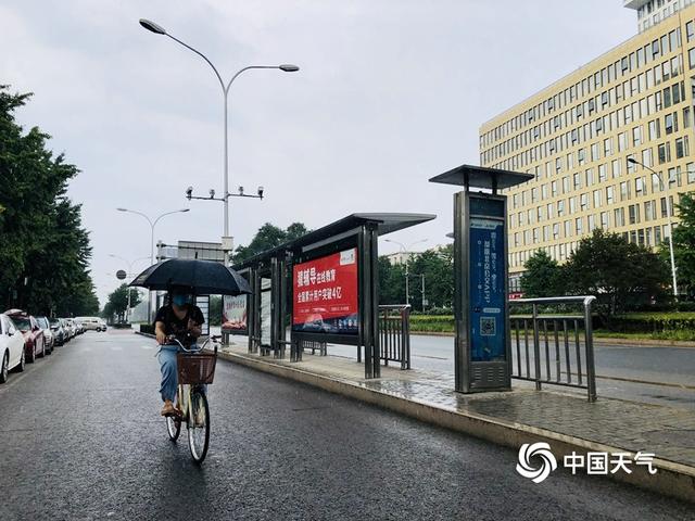 乌云携雨来 北京街头市民撑伞出行