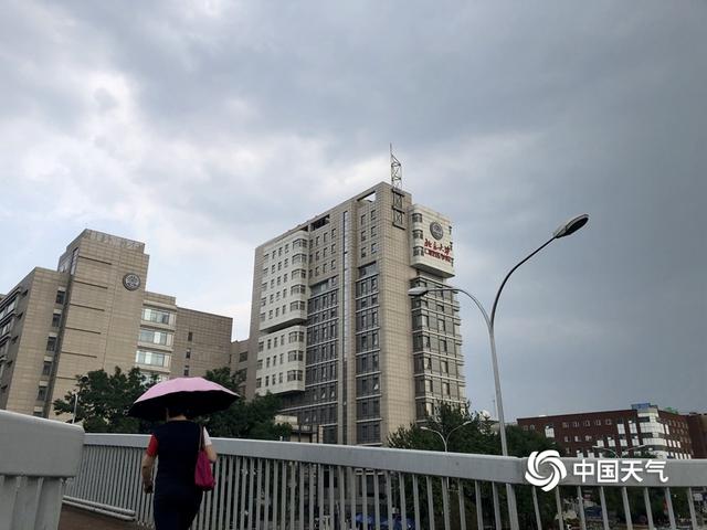 乌云携雨来 北京街头市民撑伞出行