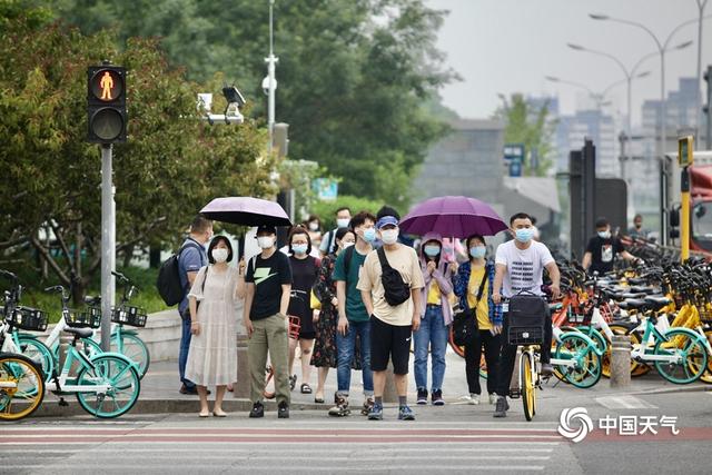 北京早高峰行人撑伞出行 今天大部地区仍有阵雨