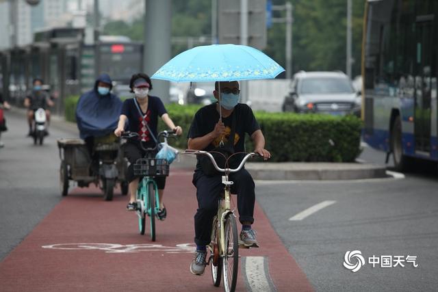 北京早高峰行人撑伞出行 今天大部地区仍有阵雨