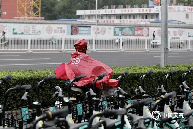 北京早高峰行人撑伞出行 今天大部地区仍有阵雨