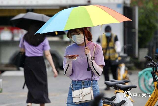 北京早高峰行人撑伞出行 今天大部地区仍有阵雨