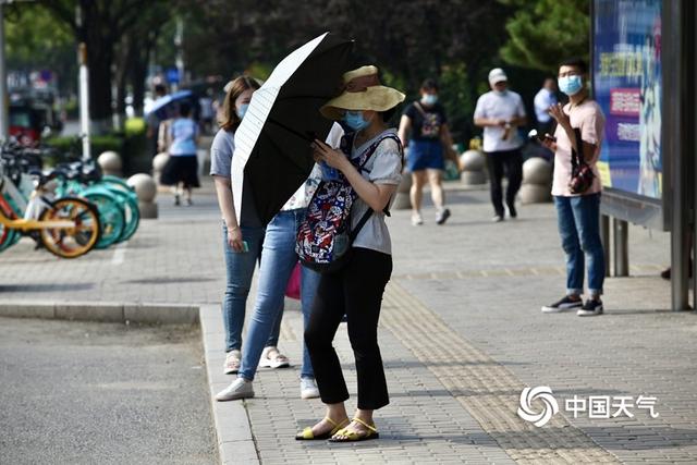 入伏首日北京闷热“应景”街头行人防晒包裹严实