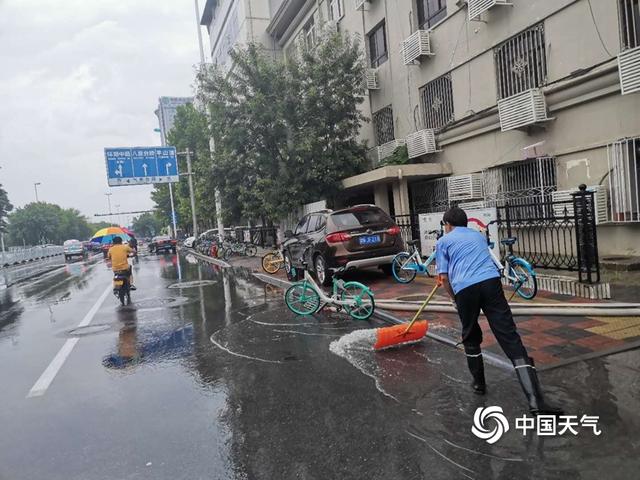 天津降雨路面湿滑 工作人员清理积水忙