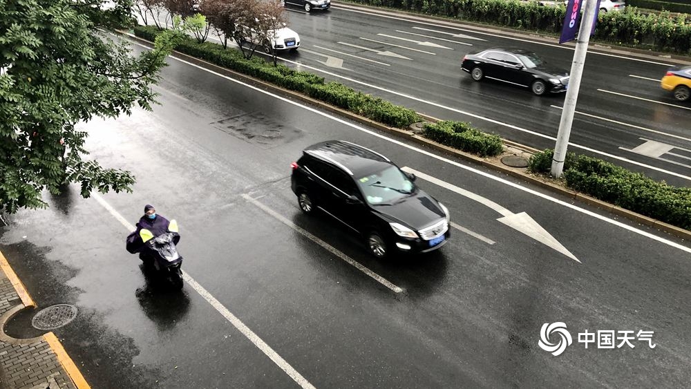 北京雨水添凉意 天空阴沉路面湿滑