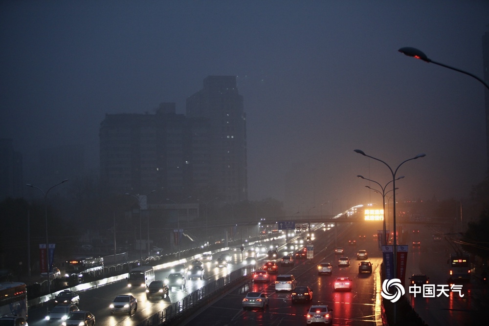 北京遭遇入冬后首场降雨 道路湿滑行人撑伞出行