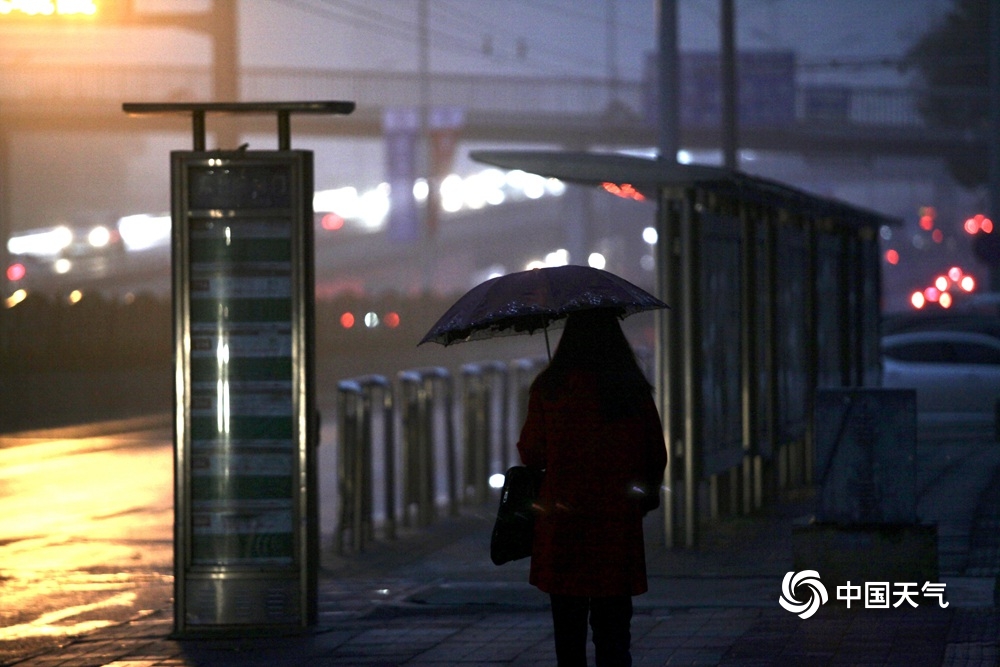 北京遭遇入冬后首场降雨 道路湿滑行人撑伞出行