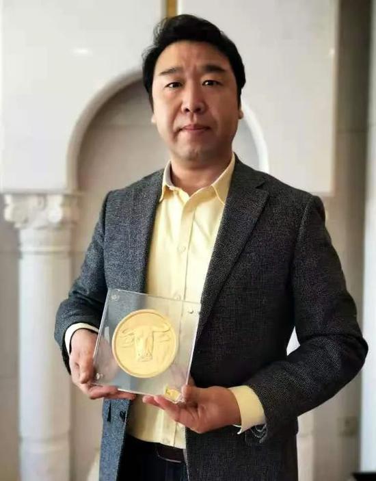 中国人民银行发行的辛丑（牛）年金制纪念币作者刘中先生手捧2公斤金制纪念币合影留念