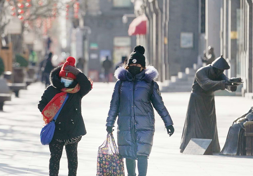 2021年首轮极寒天气！前门步行街行人在风寒中前行