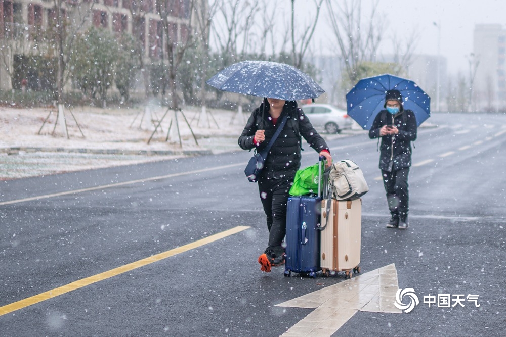 江西共青城市现明显降雪 学生顶风雪返乡