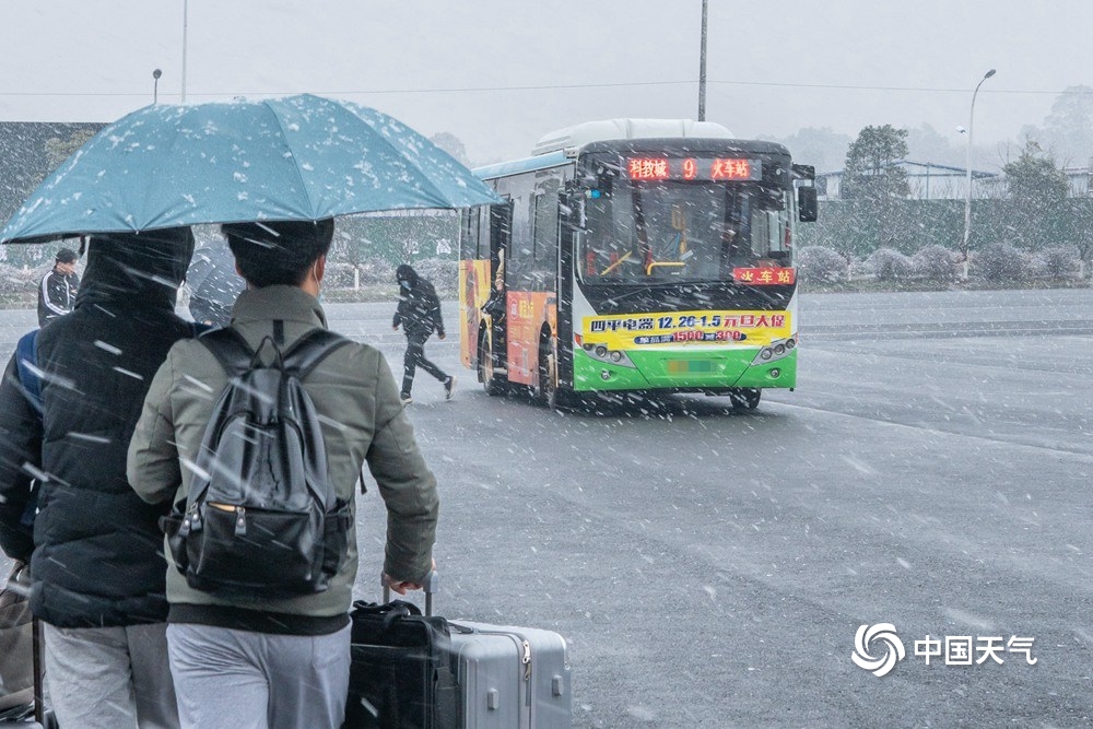 江西共青城市现明显降雪 学生顶风雪返乡