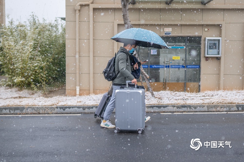 江西共青城市现明显降雪 学生顶风雪返乡