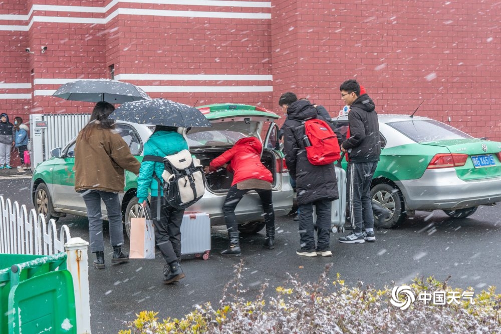 江西共青城市现明显降雪 学生顶风雪返乡