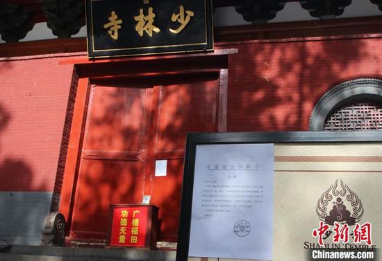 1月13日,为配合新冠肺炎疫情防控,位于河南的嵩山少林寺、洛阳白马寺、开封大相国寺等中原名寺,再度“闭门谢客”,暂停对外开放。图为少林寺前张贴的暂停开放公告。 中新社发 安萌 摄