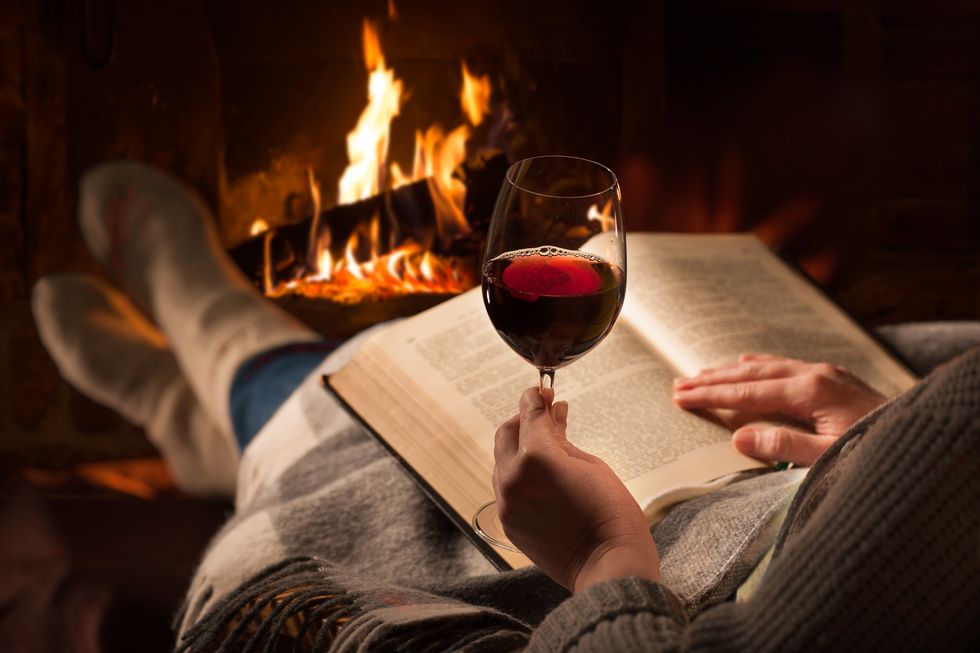 woman-reads-book-near-fireplace-royalty-free-image-1604024421-.jpg