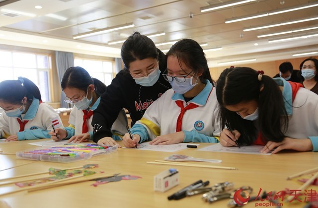 在老师指导下，学生制作皮影。人民网 崔新耀摄